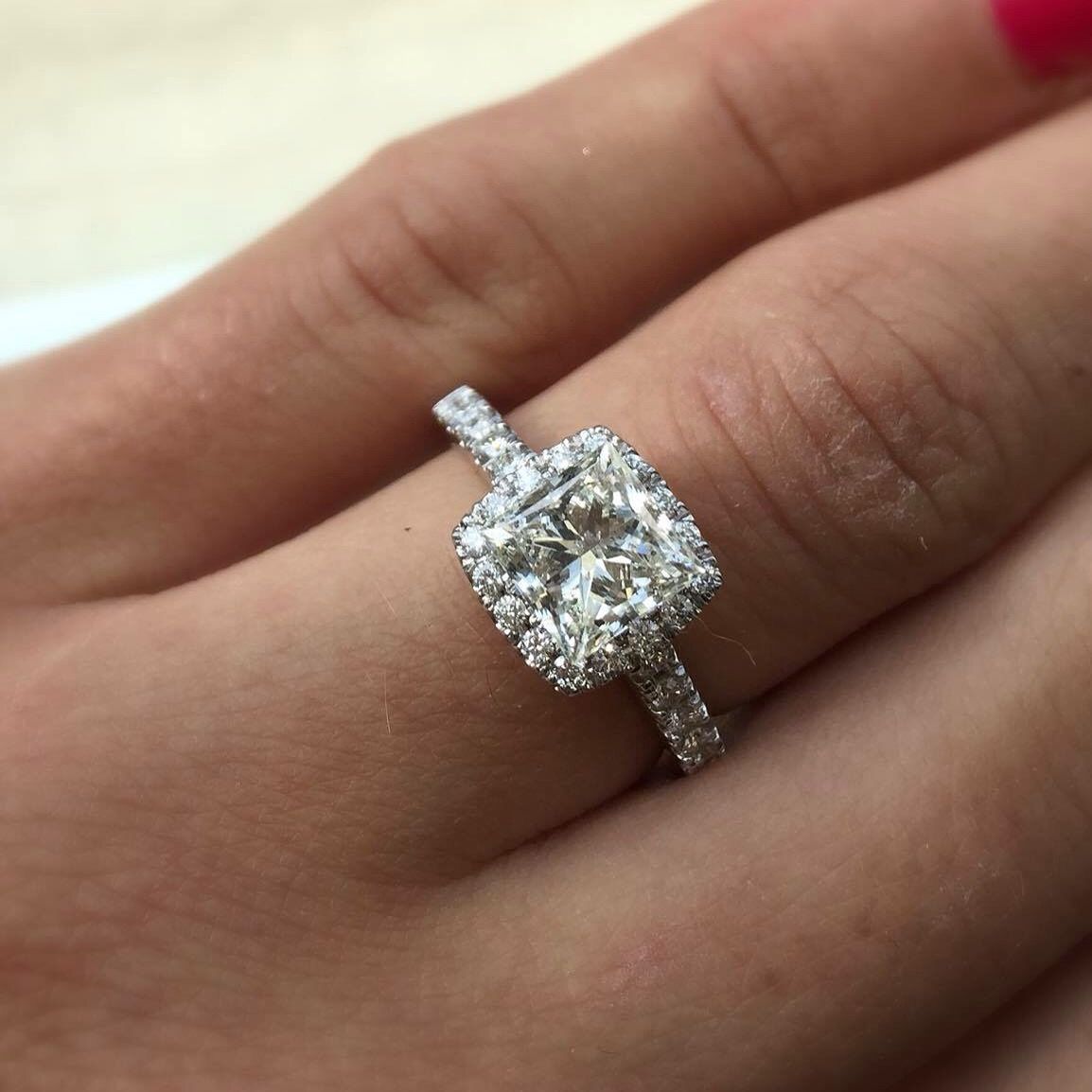 A woman is wearing a diamond ring on her left hand