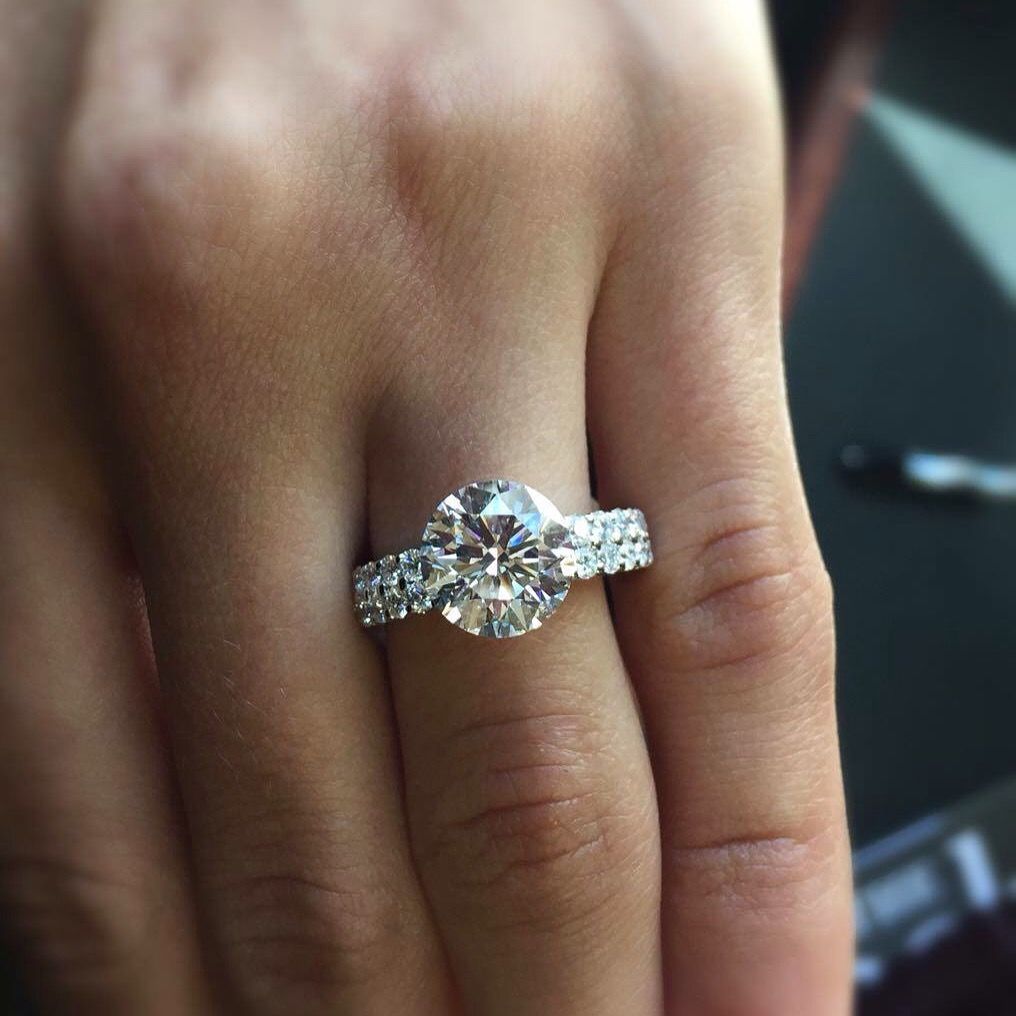 A woman is wearing a diamond ring on her left hand