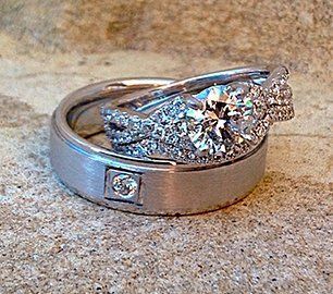 A couple of wedding rings sitting on top of a sandy surface