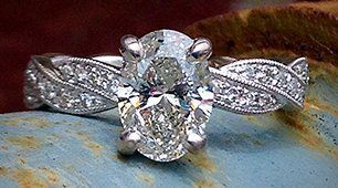 A diamond ring is sitting on a blue surface.