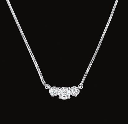 A necklace with three diamonds on a chain on a black background