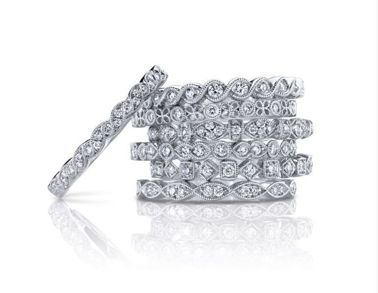 A stack of diamond rings are sitting on top of each other on a white surface.