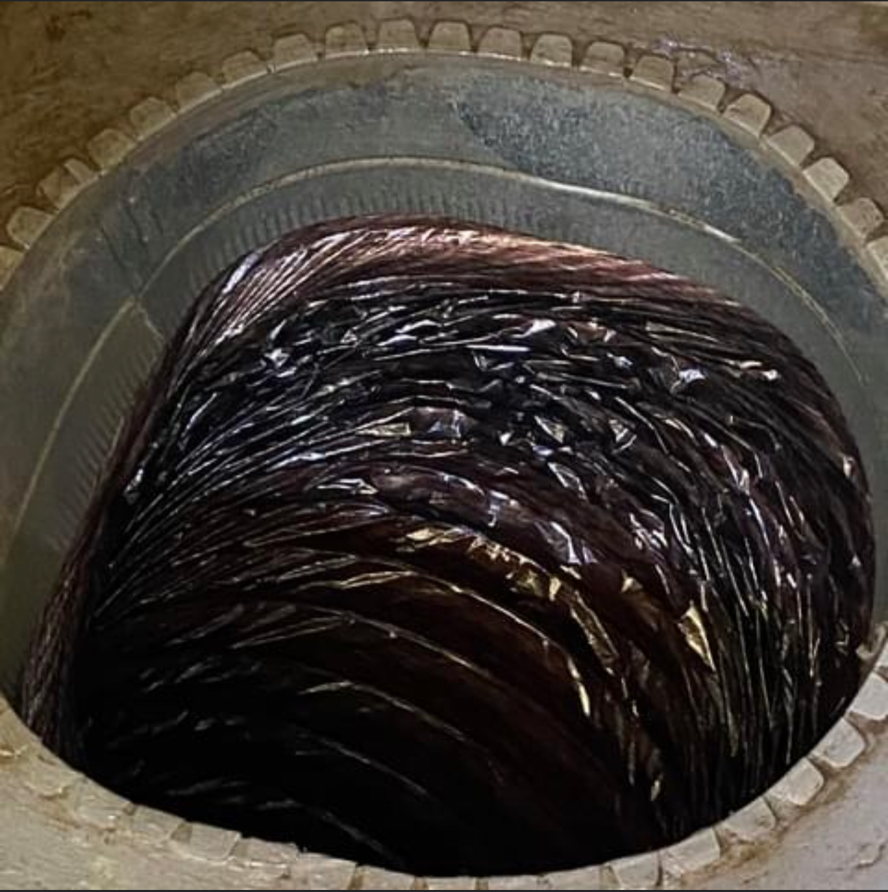 A large hole in the ground with a lot of water coming out of it