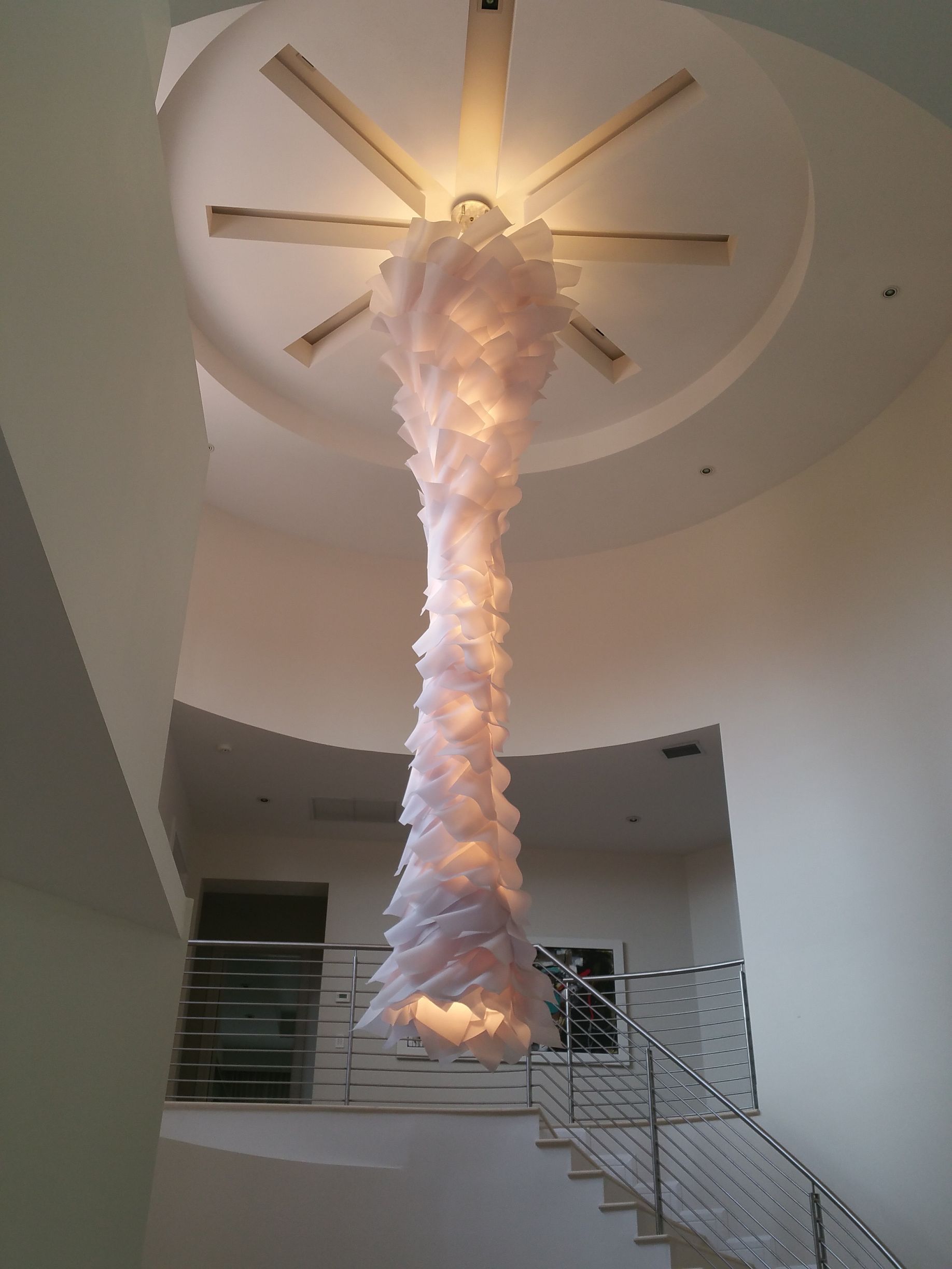 Statement chandelier lighting fixture in luxury home foyer with recessed ceiling design