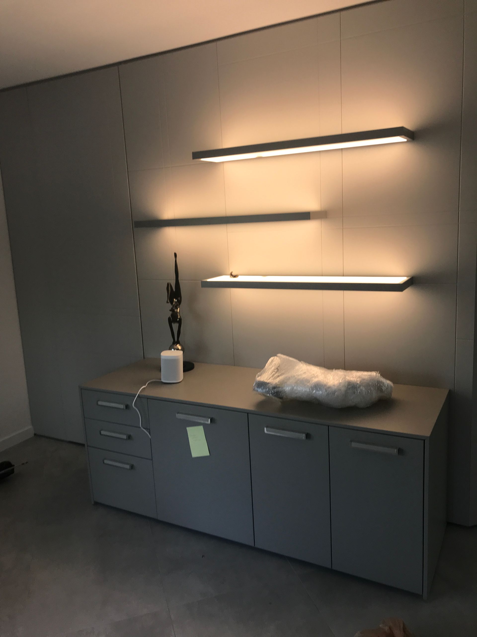 Custom lighting design with wall-mounted LED shelf lights in modern living space