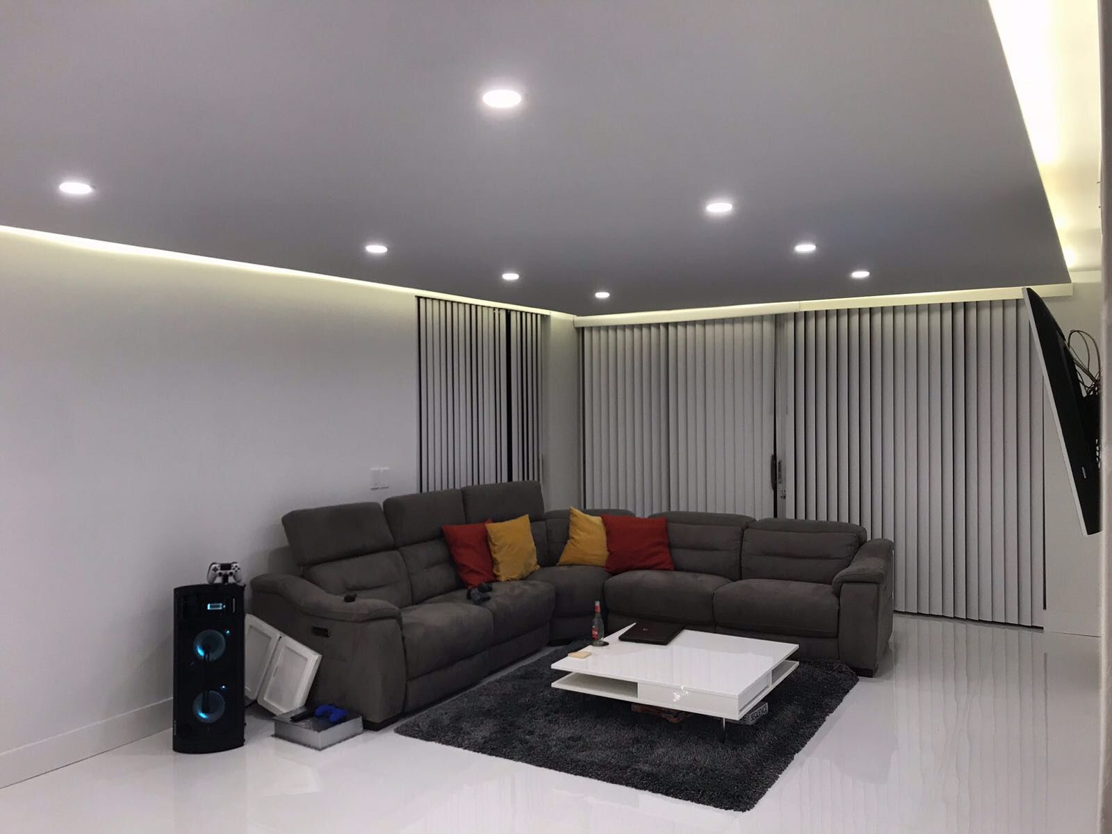 Custom recessed lighting and wall-mounted TV setup in smart home living room