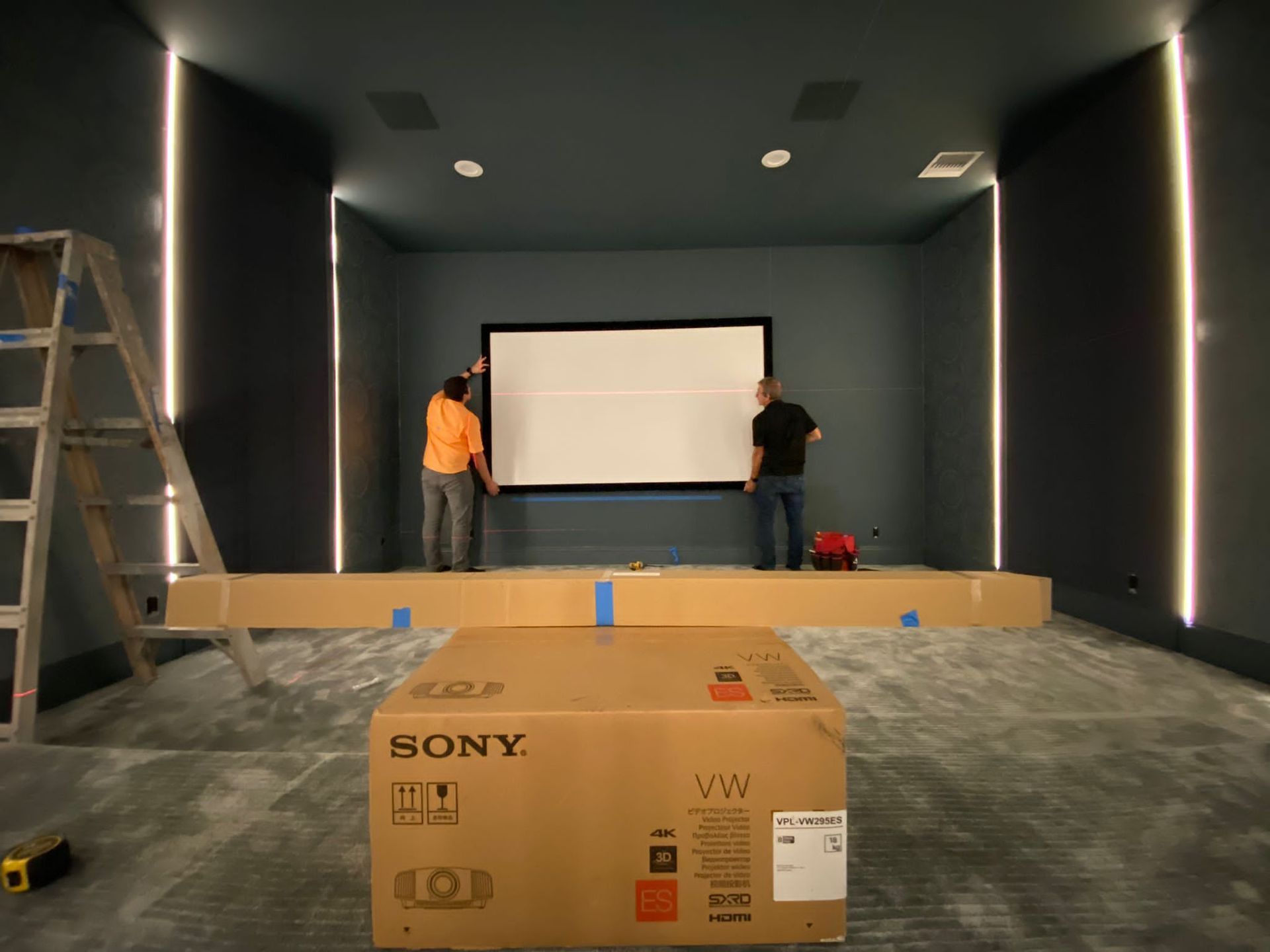 Home theater installation with projector screen setup and custom lighting design