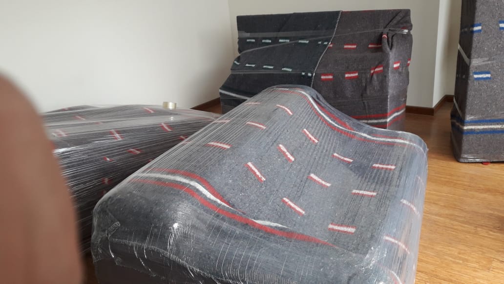 Un sofá está envuelto en plástico de burbujas en una habitación.