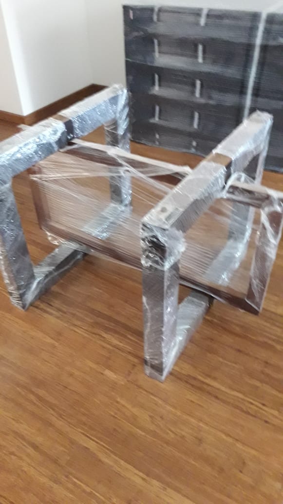 Una silla está envuelta en plástico y sentada sobre un suelo de madera.