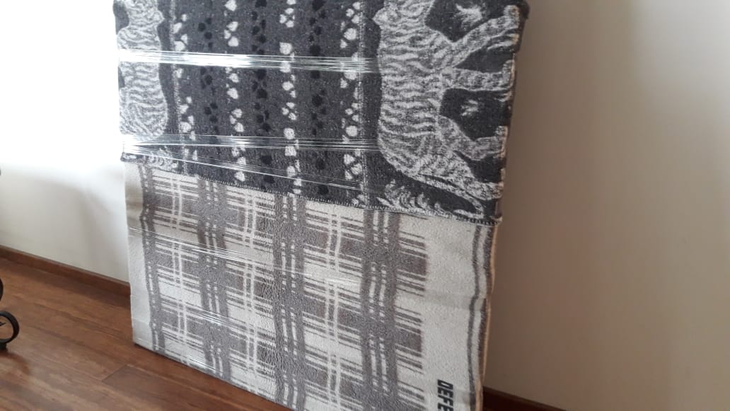 Una pintura en blanco y negro está sobre un suelo de madera junto a una ventana.