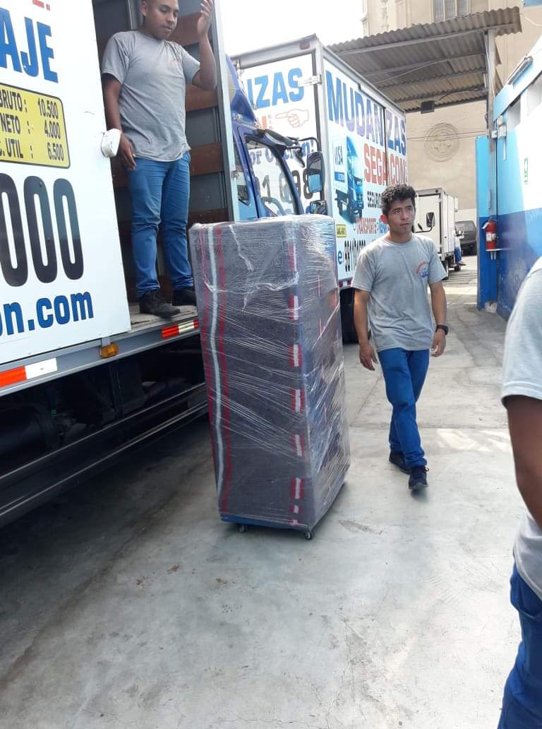 Dos hombres están parados frente a un camión en movimiento.