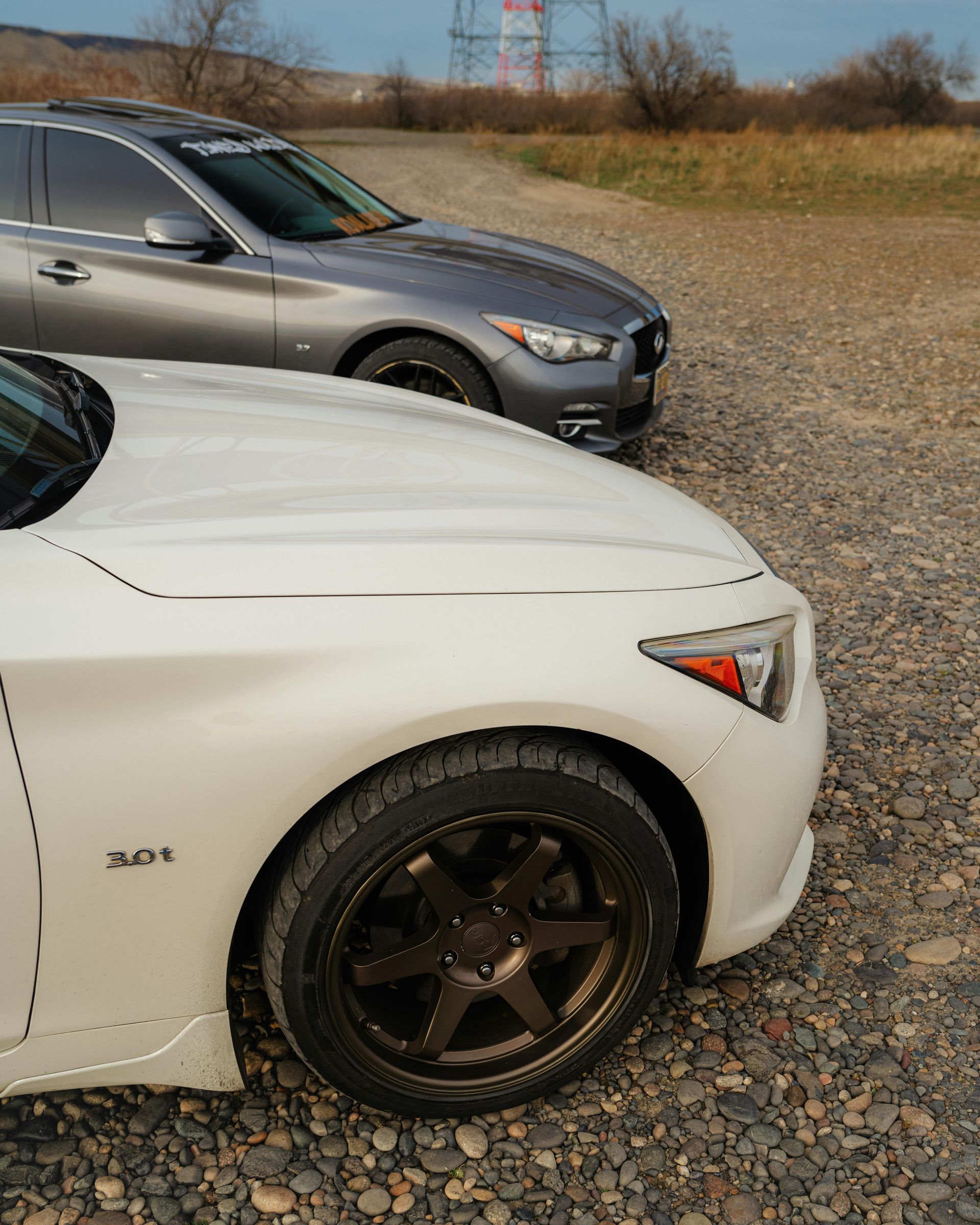 A bulldozer is carrying a large tree stump on a dirt road.