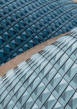 A close up of a building with a geometric pattern on the roof.