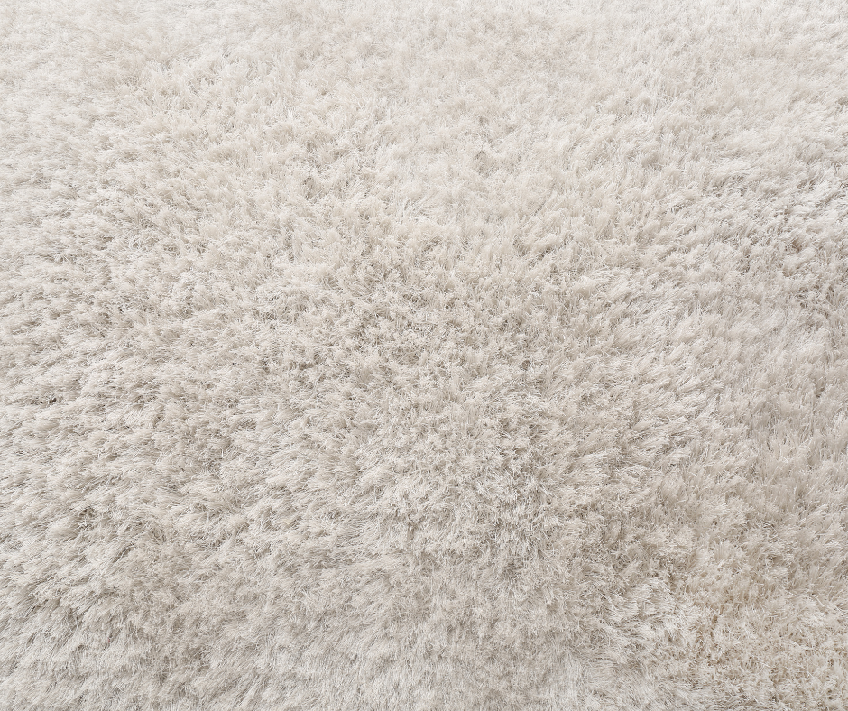 Gros plan sur un tapis à poils longs de couleur claire.