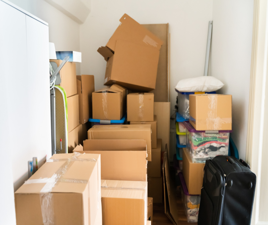 Des cartons empilés dans un débarras encombré.