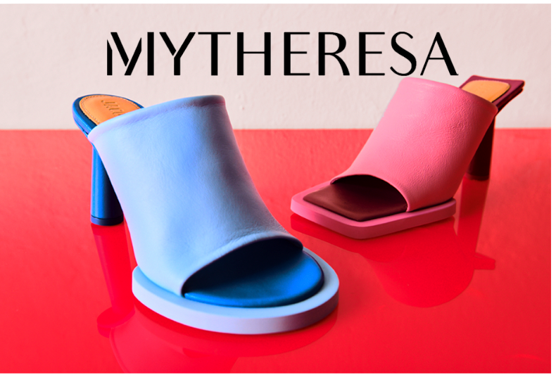 Zwei Pantoletten mit Absatz, eine blau und eine rosa, auf rotem Untergrund; Mytheresa-Logo im Hintergrund.