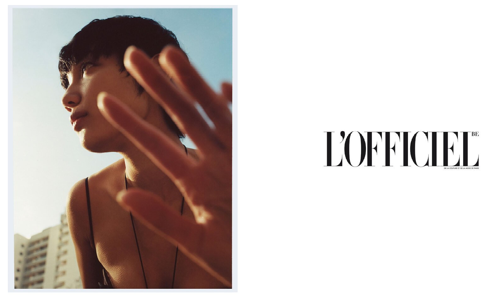 Frau mit kurzen Haaren, die ihre Augen mit der Hand abschirmt, in der Nähe eines Gebäudes. L'Officiel-Logo.