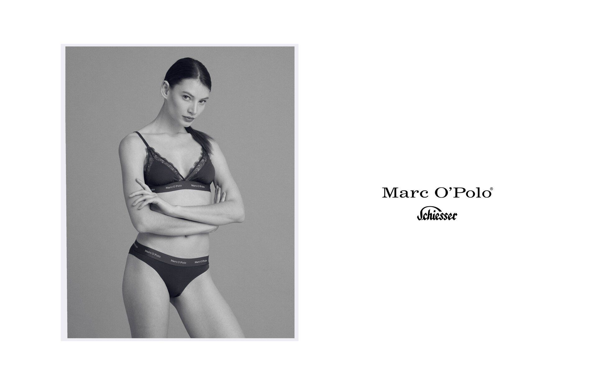 Frau in schwarzer Unterwäsche posiert mit verschränkten Armen, mit dem Marc O'Polo-Logo auf weißem Hintergrund.
