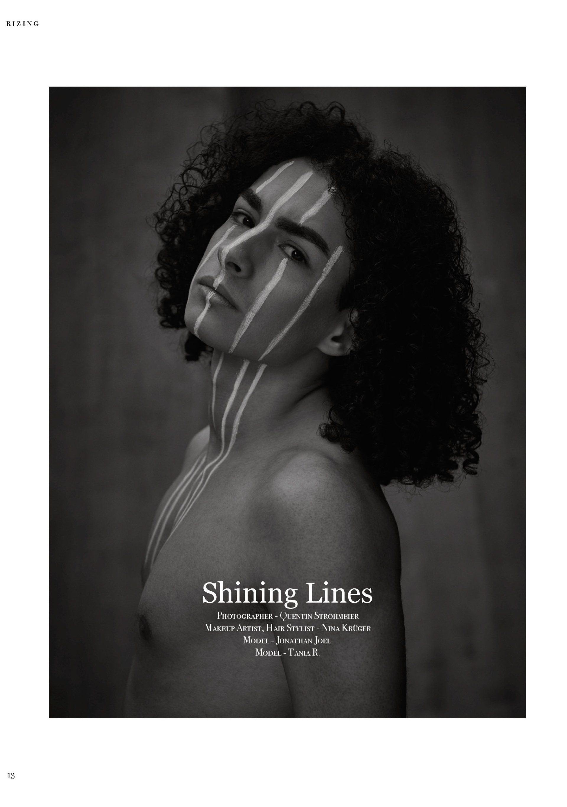 Junge Person mit lockigem Haar und Körperkunst. Schwarzweißfoto, Linien im Gesicht und auf der Brust.