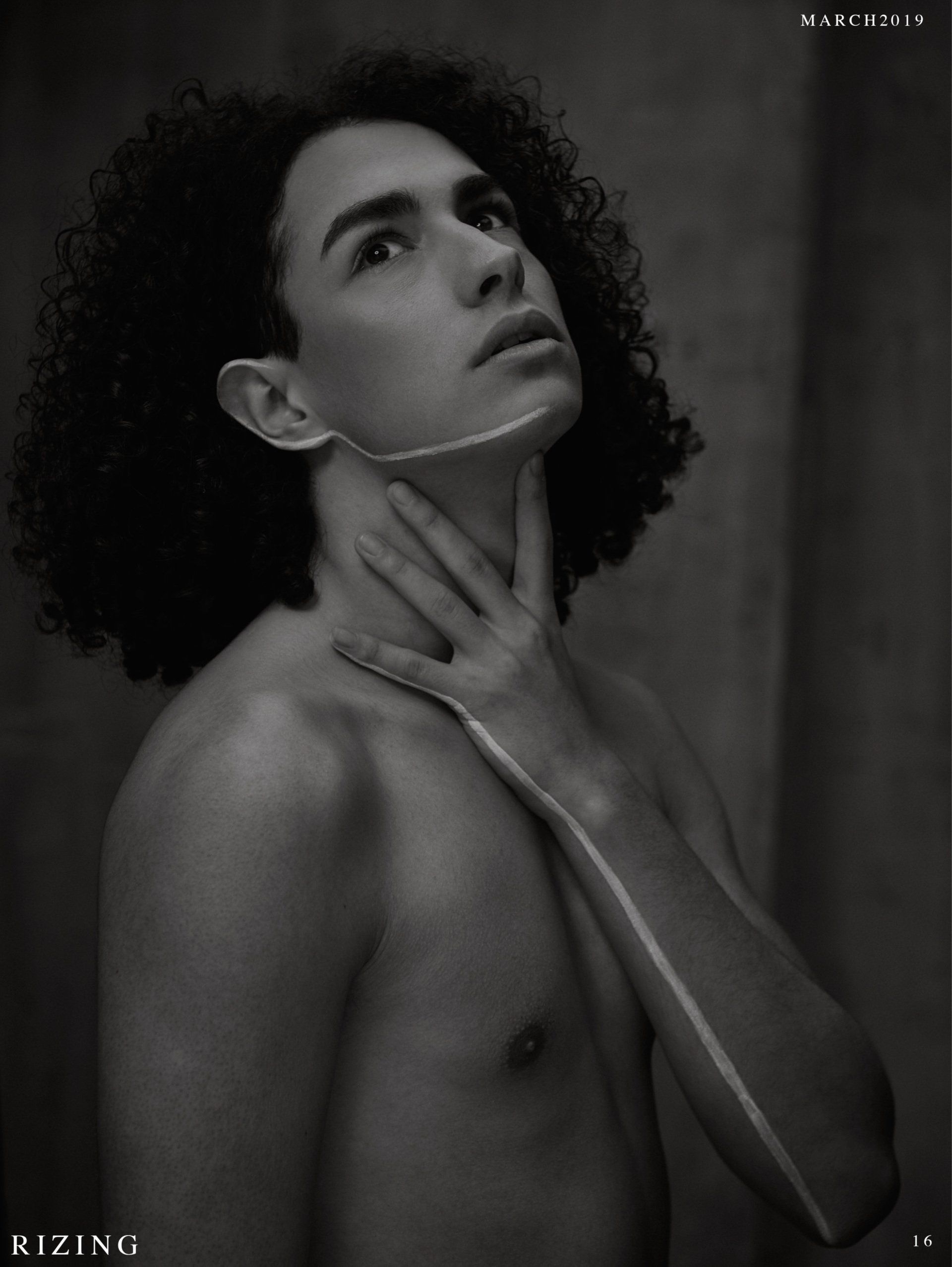 Schwarzweißfoto einer Person, die nach oben schaut. Eine Hand umreißt Hals und Gesicht. Sie hat lockiges Haar.