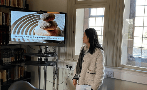 ICF-Certified Executive Coach Aries Yeo standing in front of screen giving presentation