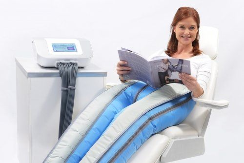 Eine Frau sitzt auf einem Stuhl und liest eine Zeitschrift.