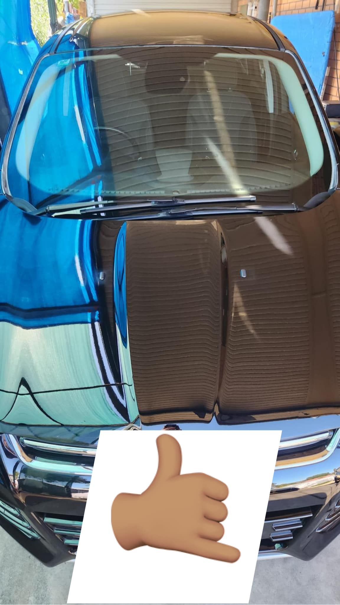 A blue car with a thumbs up sign next to it