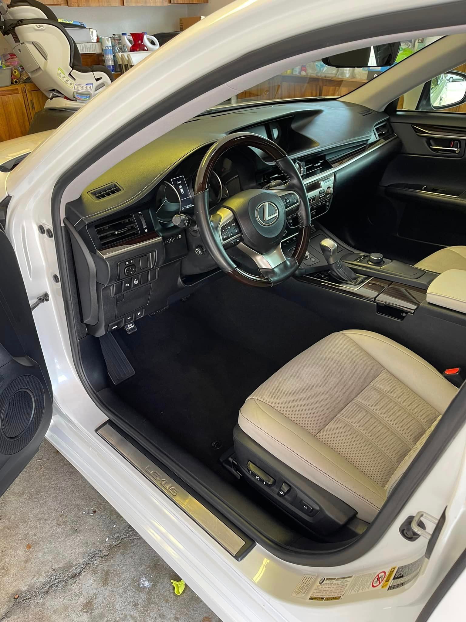 The interior of a white car with a steering wheel and seats.