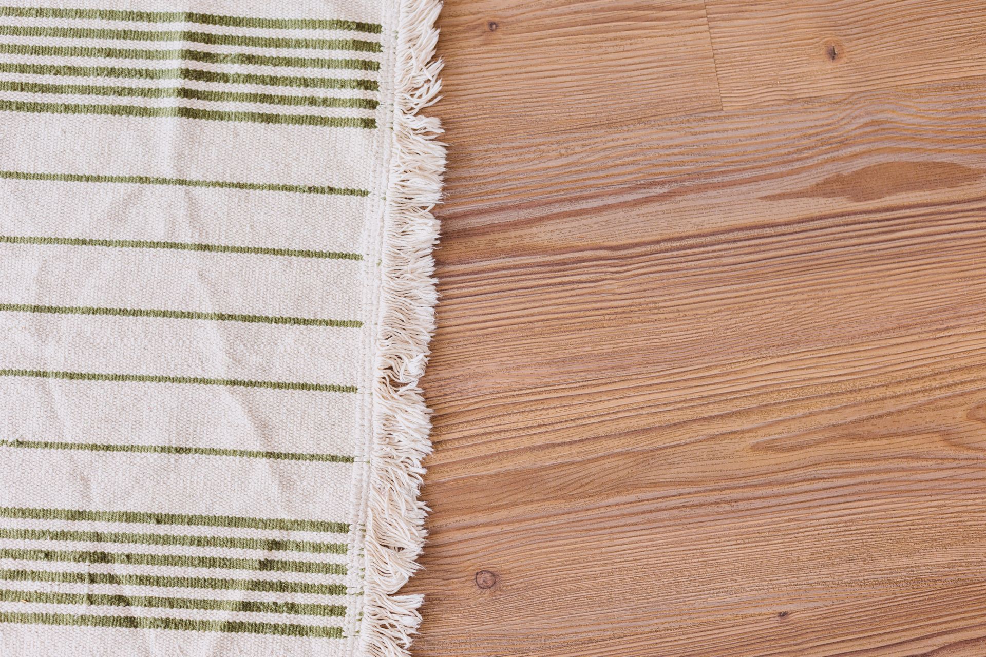 A white and green striped towel is sitting on a wooden table.