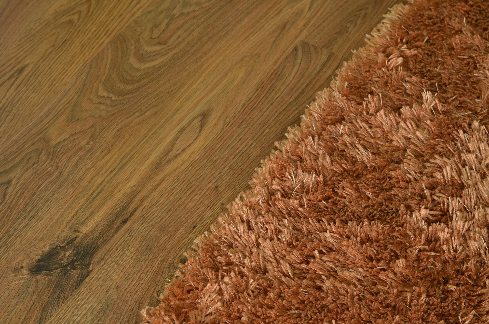 A brown rug is sitting on a wooden floor next to a wooden floor.