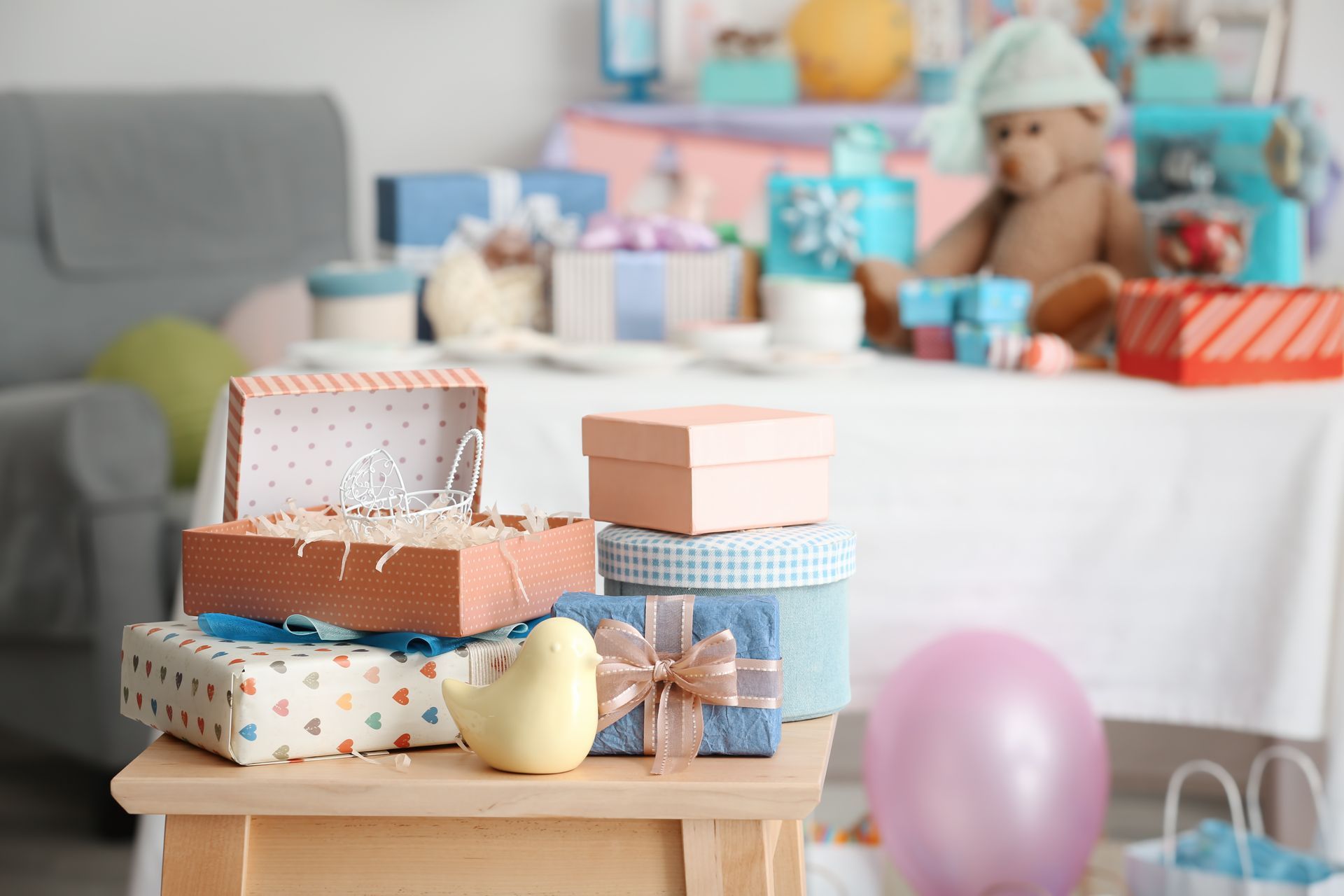 Wrapped presents stacked on a table for a baby shower