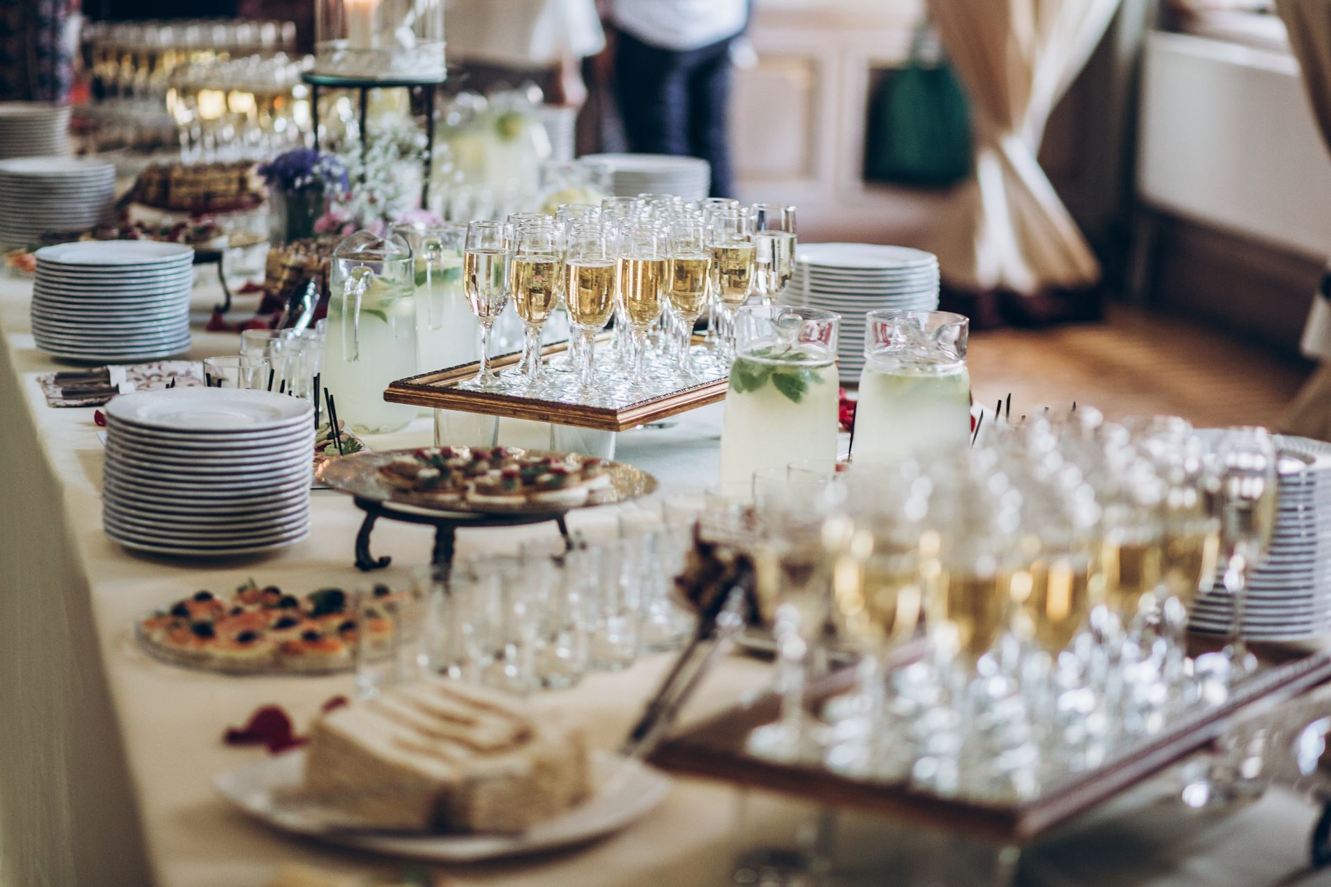 Buffet table with champagne, desserts, and refreshments in a bright room.