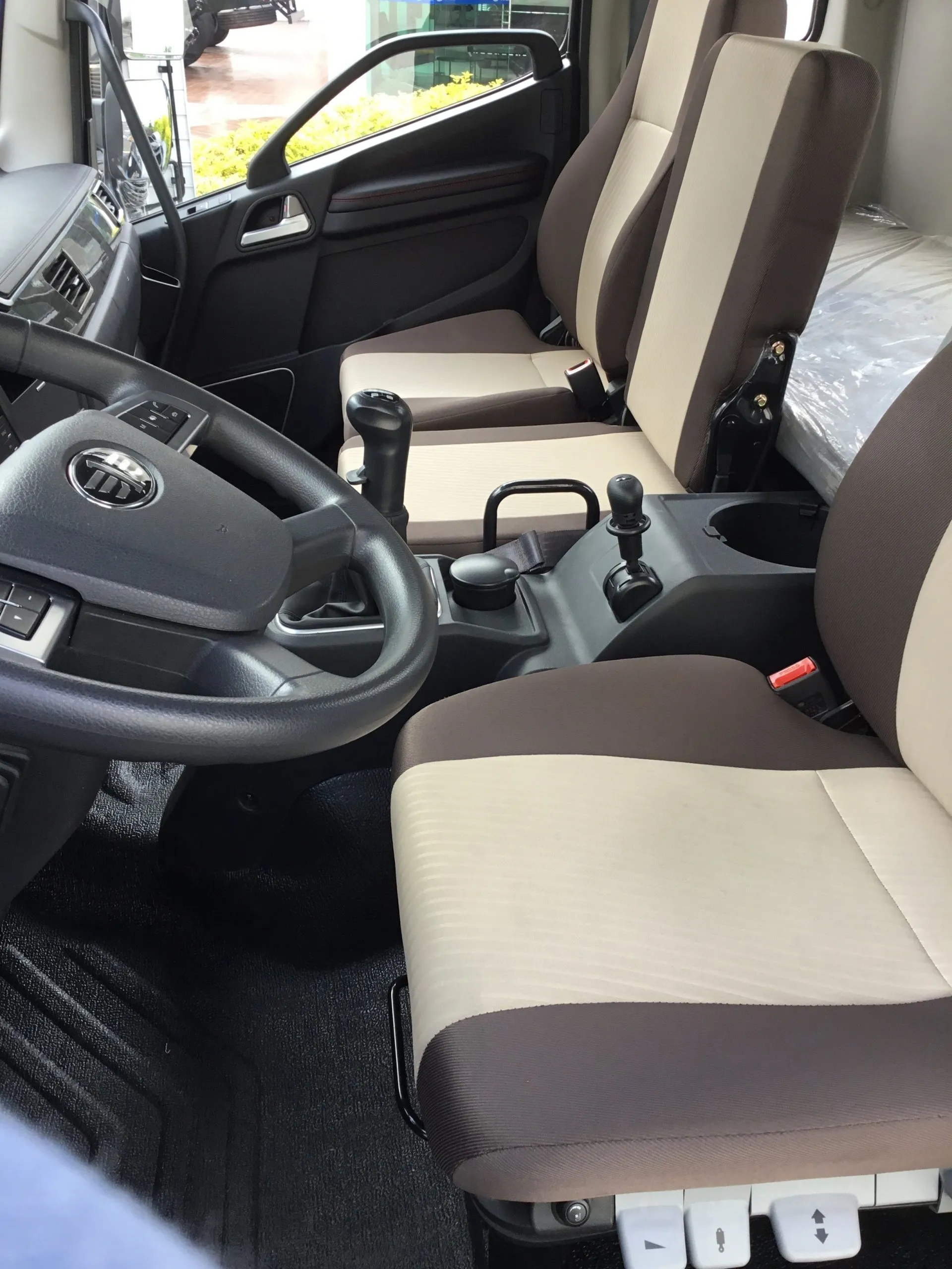 El interior de un camión con volante y asientos.