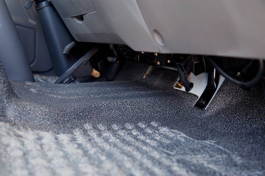 Un primer plano del pedal del freno de un coche.