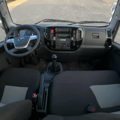 El interior de un camión con volante y asientos.