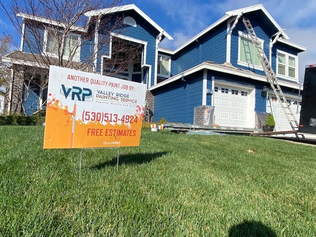 Blue house being painted; sign says 