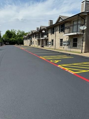 A row of apartment buildings with a parking lot in front of them.