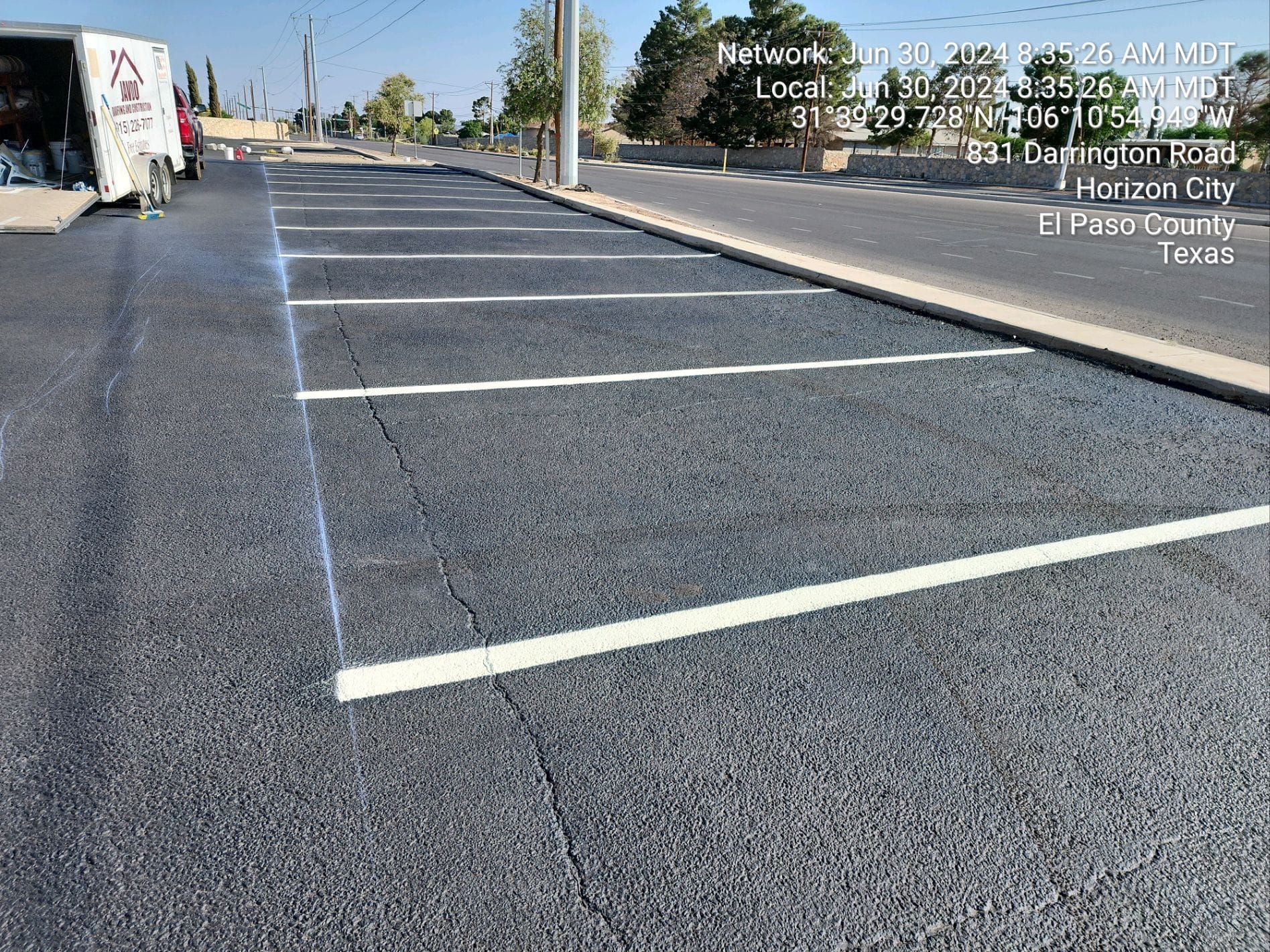 A parking lot with white lines on it and a truck in the background.