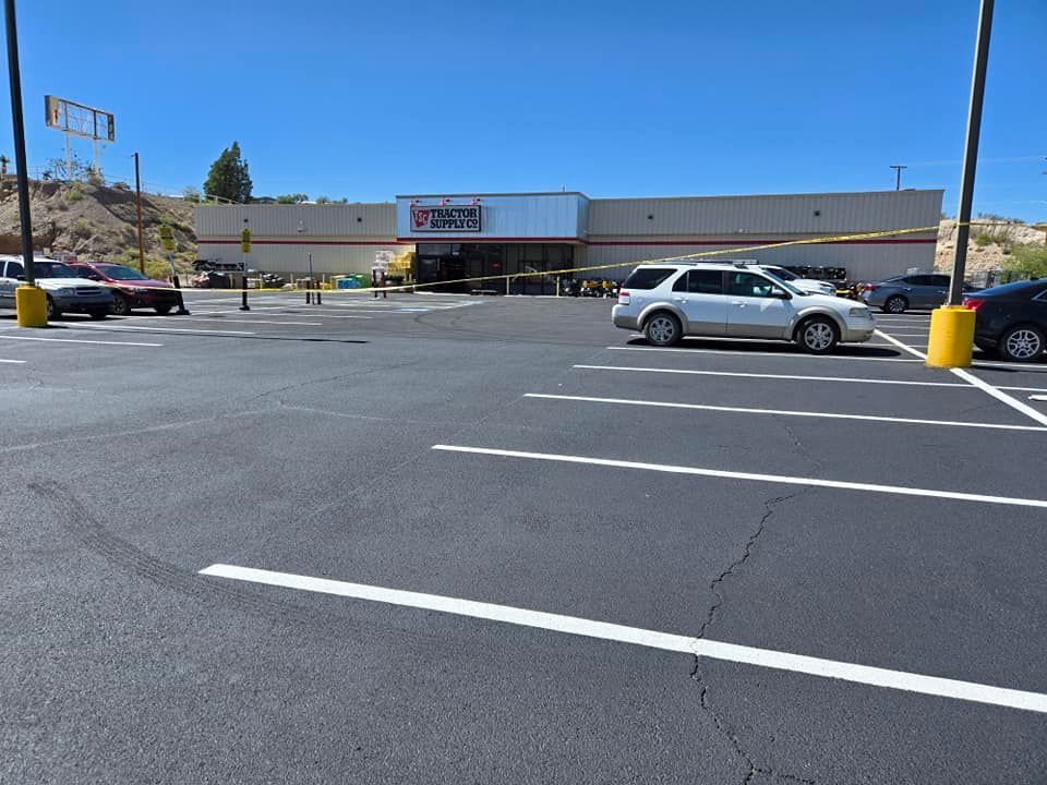 A white van is parked in a parking lot in front of a store.