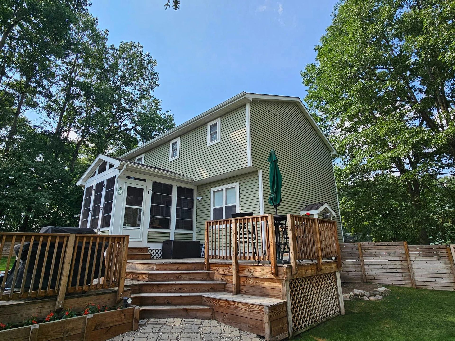 A house with a large deck and a screened in porch