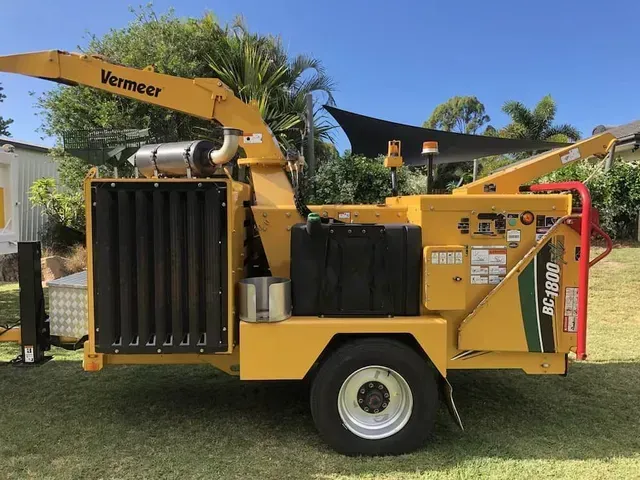 Yellow Vermeer wood chipper on wheels, parked on grass — Boyne Island Tree Services in Boyne Island, QLD