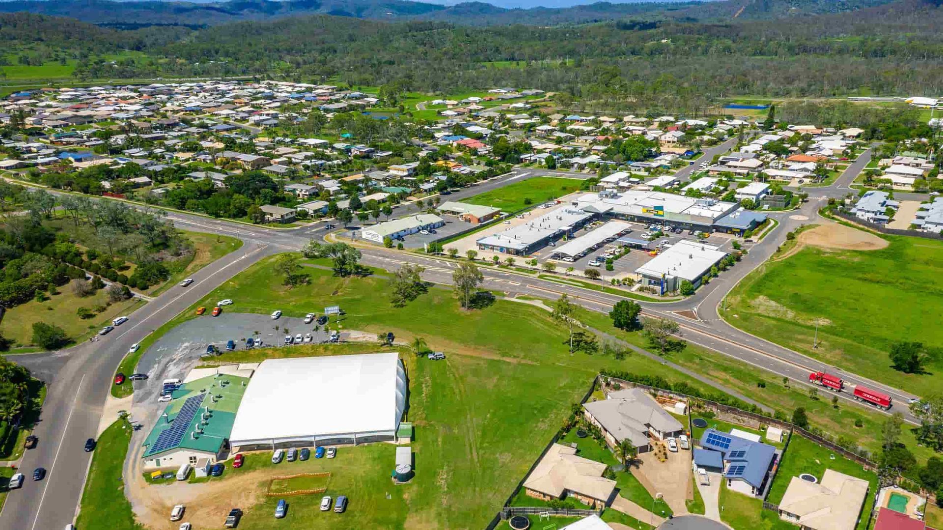 An Aerial View of A Small Town with A Large White Building in The Middle of It — Boyne Island Tree Services in Calliope, QLD