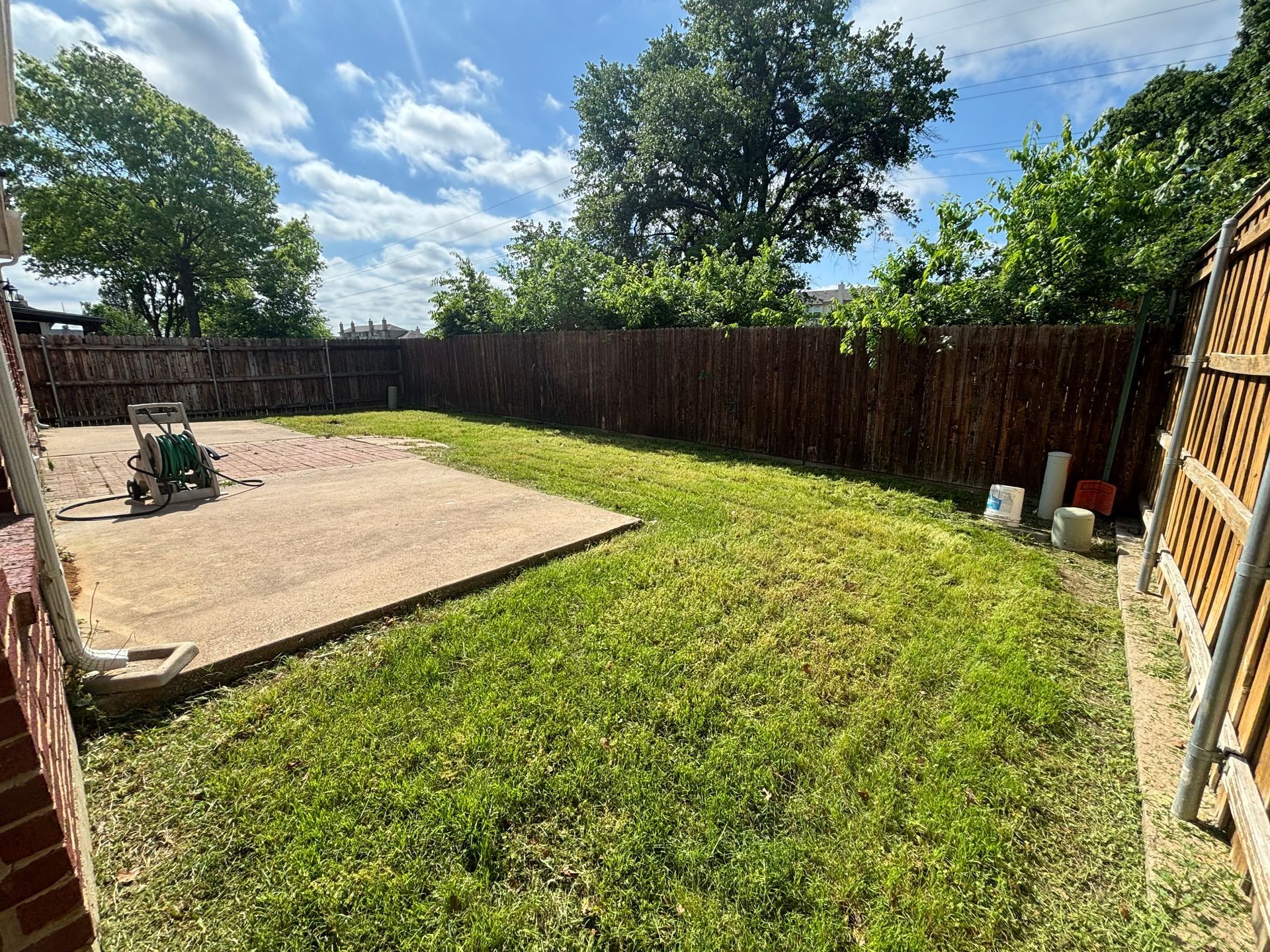 There is a lawn mower in the backyard of a house.