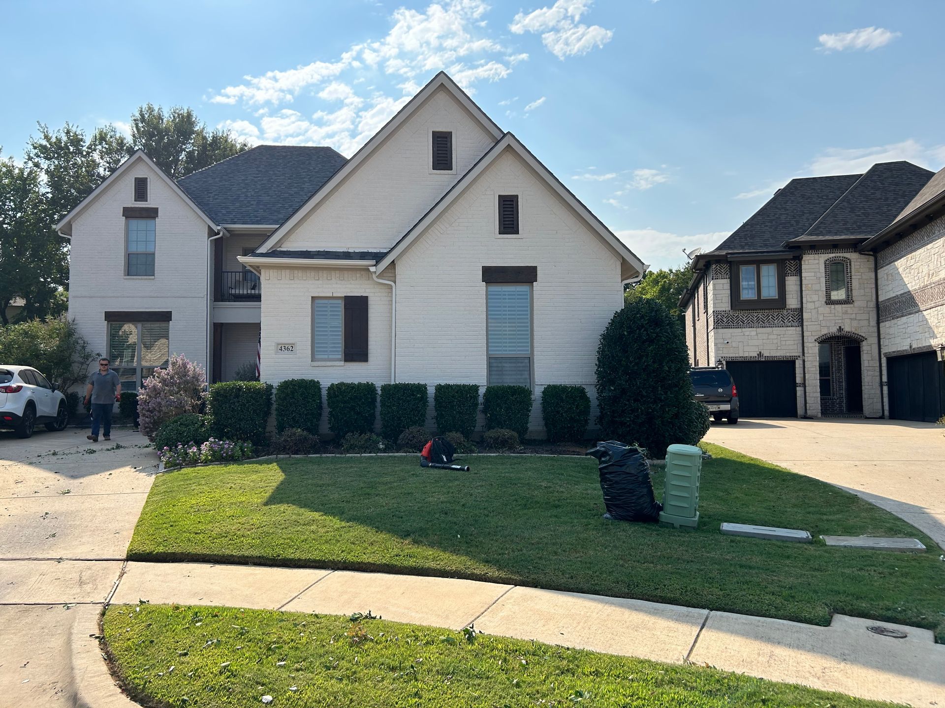 A large white house with a lush green lawn in front of it