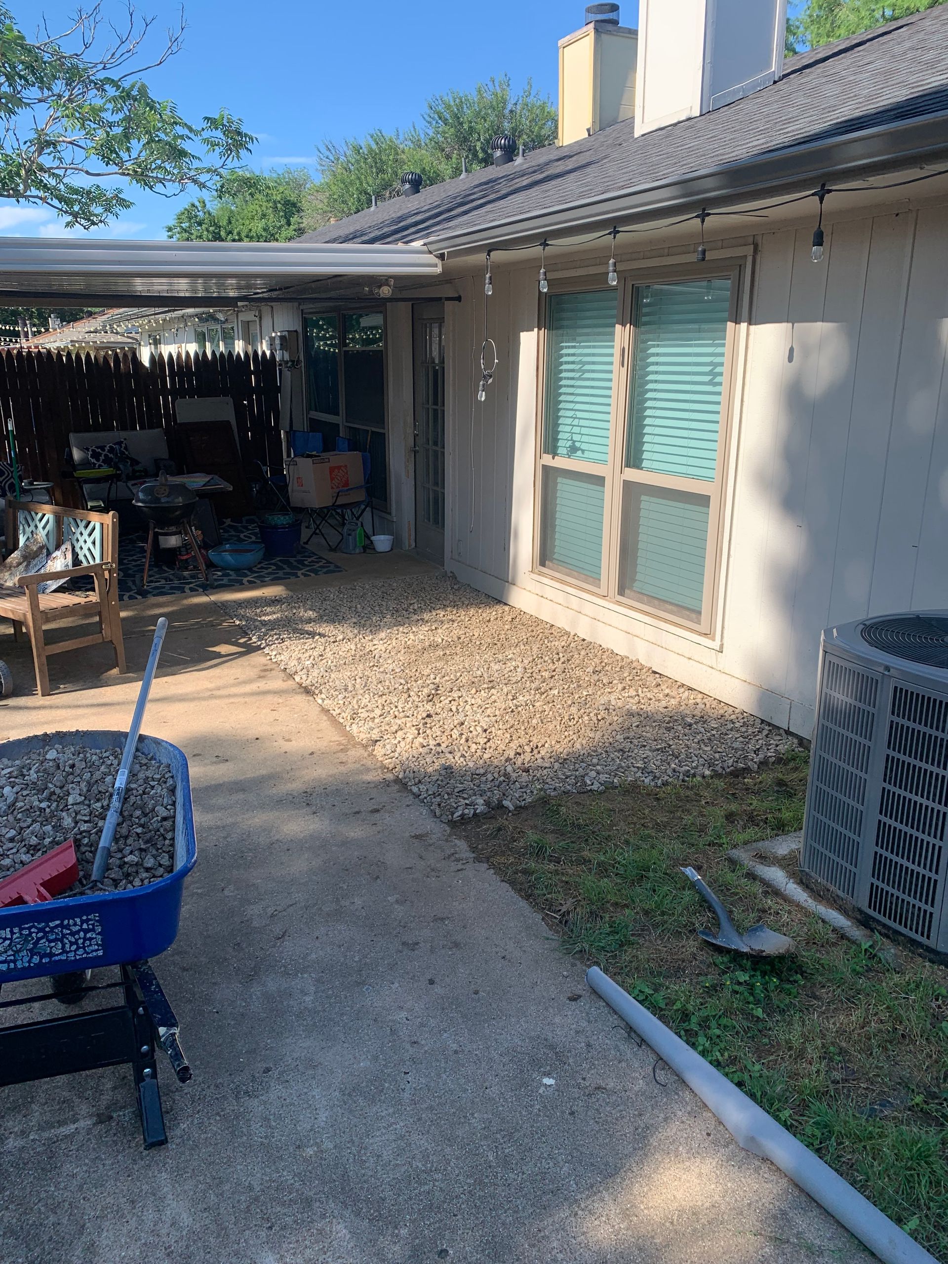 A wheelbarrow is sitting in front of a house.