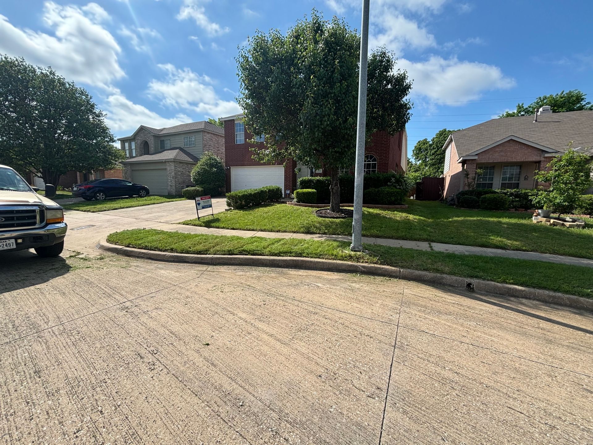A truck is parked on the side of the road in front of a house.