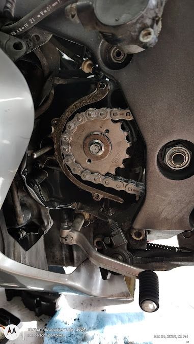 Close-up of a motorcycle engine timing chain and sprocket with the cover removed