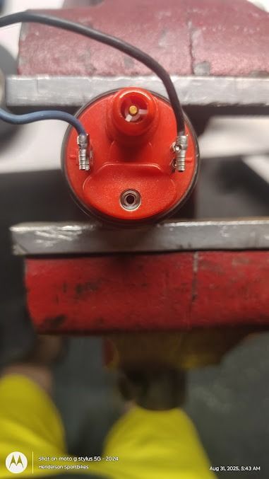 Red industrial component with wires mounted against a metal machine frame.