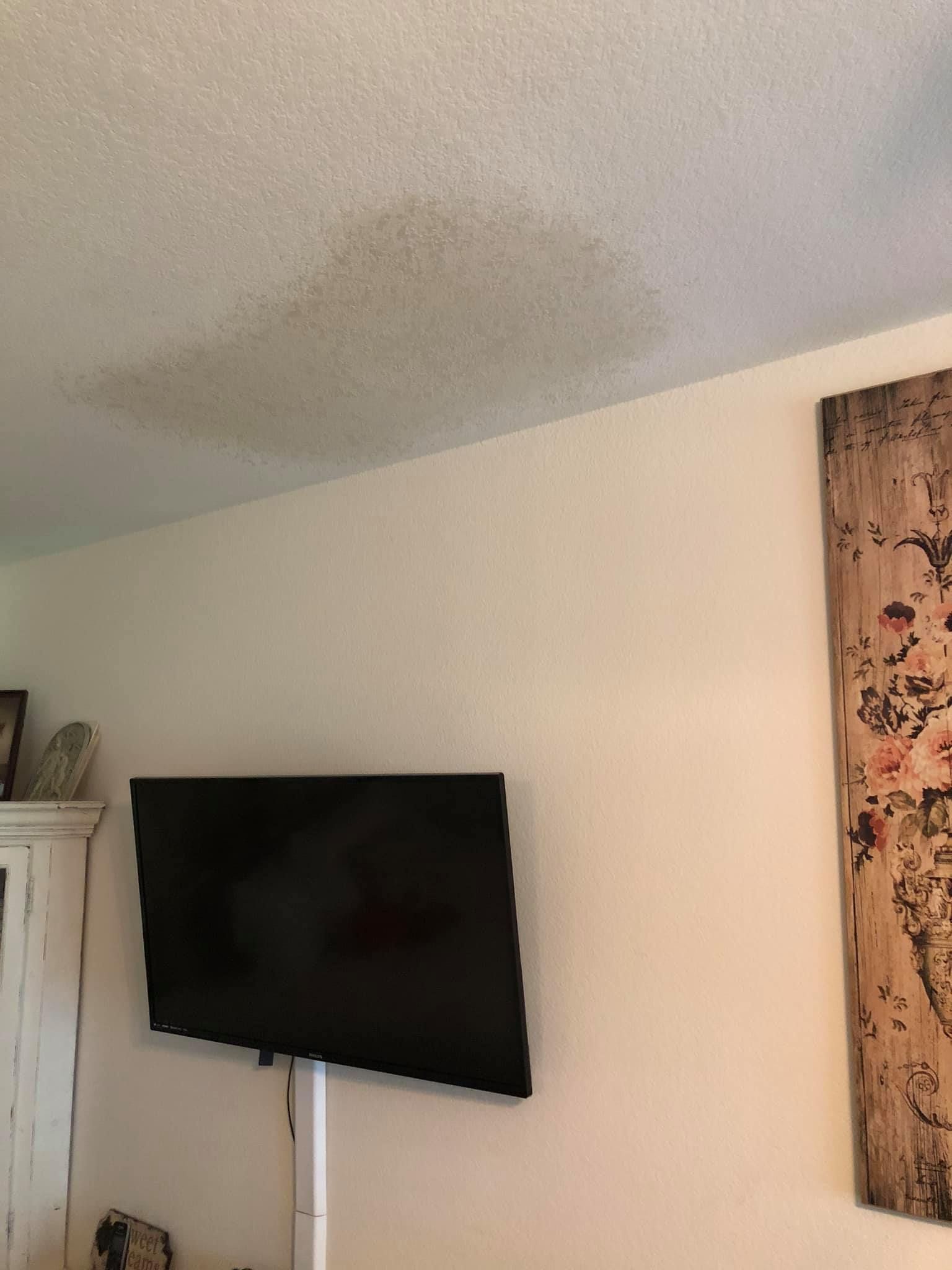 A flat screen tv is mounted to the wall in a living room.