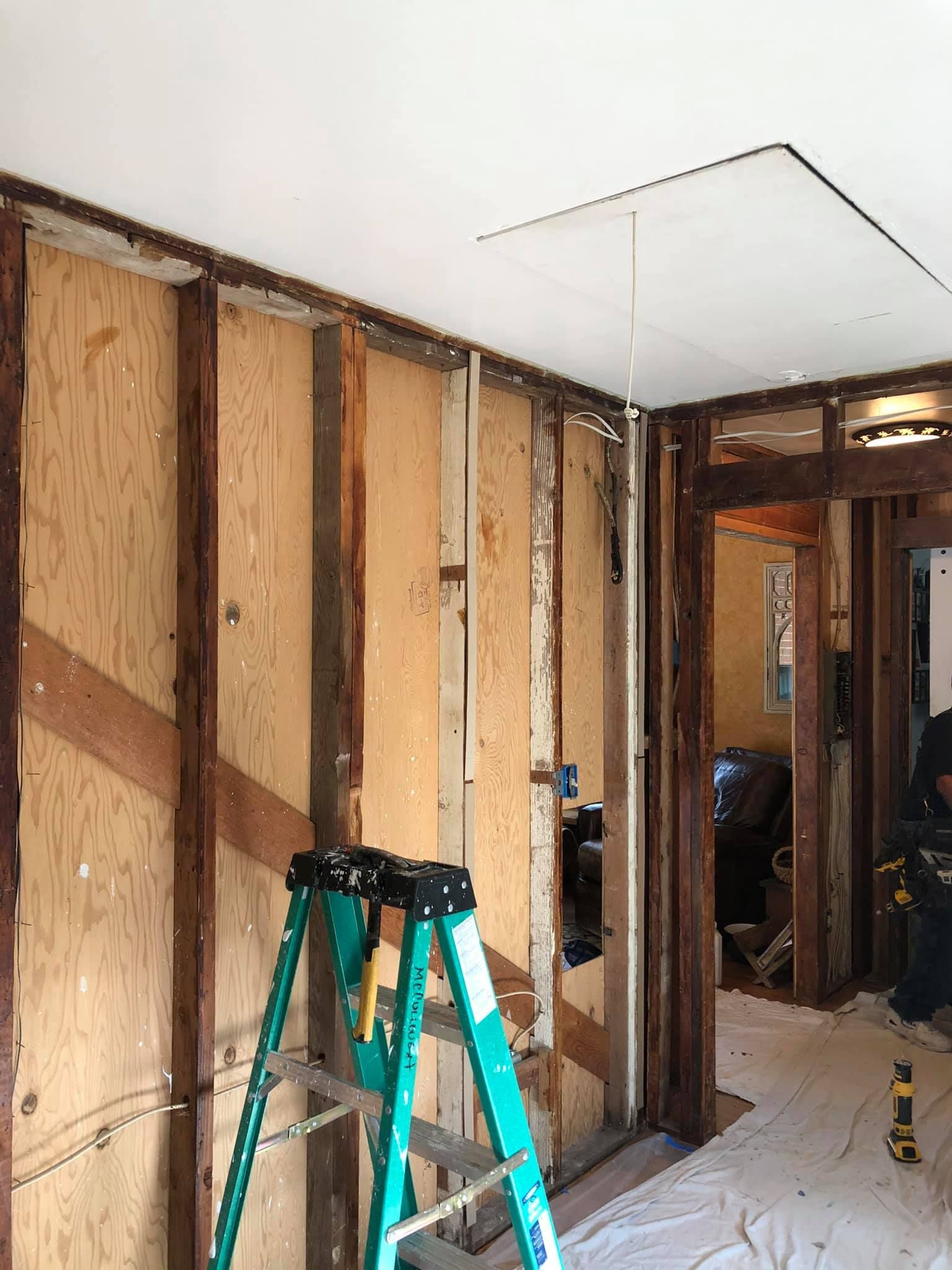 A green ladder is sitting in the middle of a room.